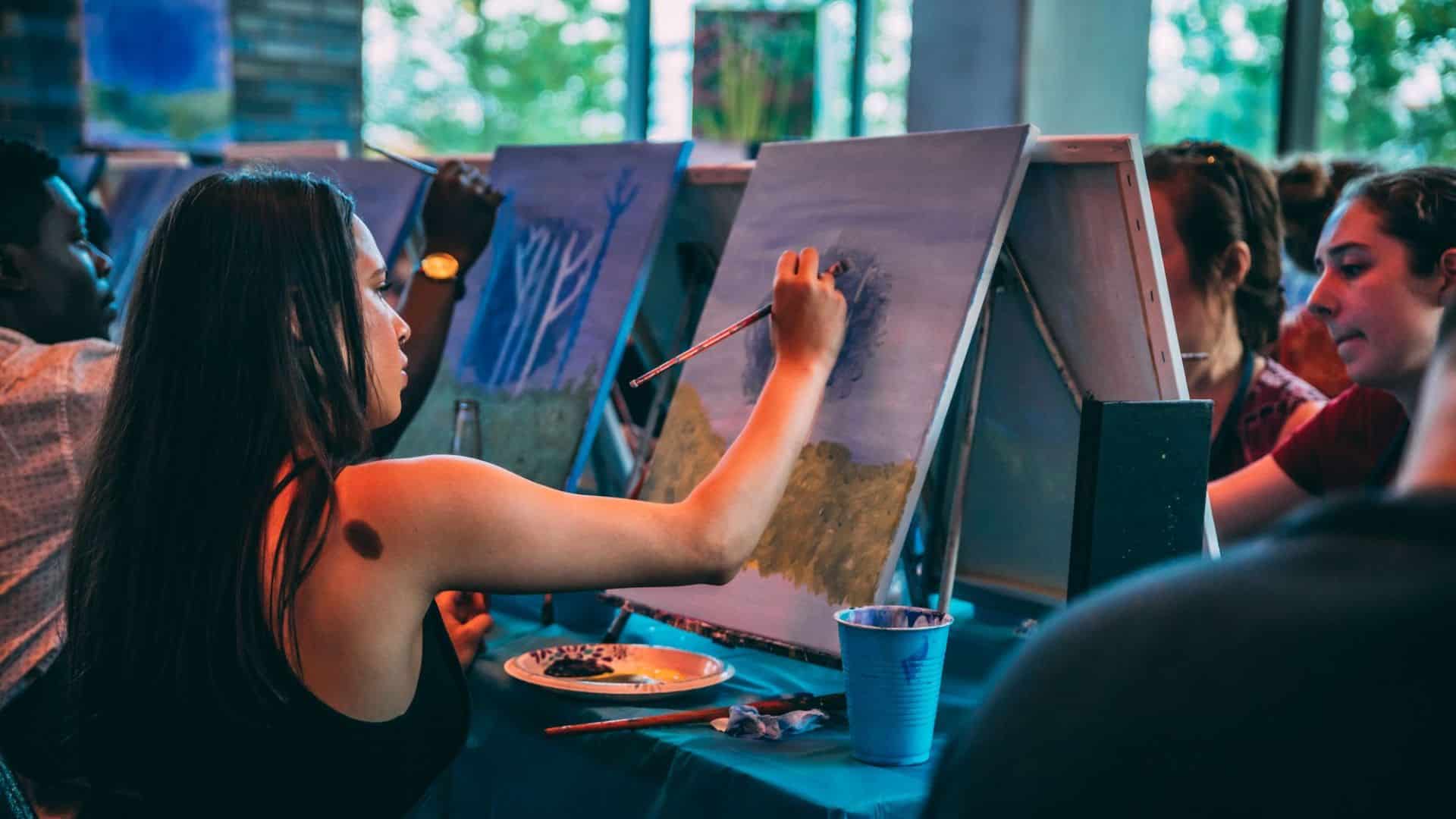 Junge Frau malt ein Bild auf einer Leinwand
