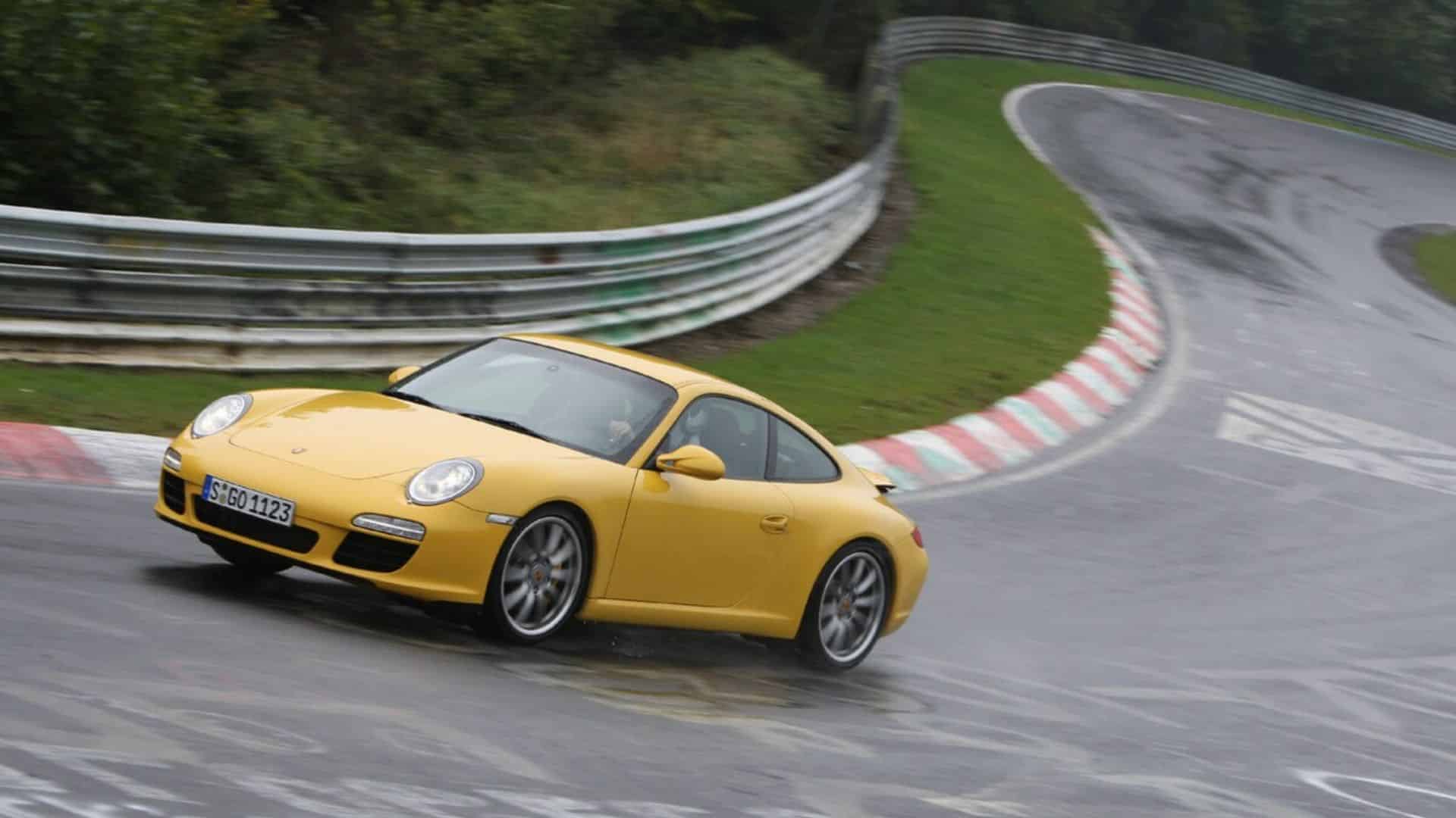 gelber Porsche 911 fährt auf einer Rennstrecke um die Kurve