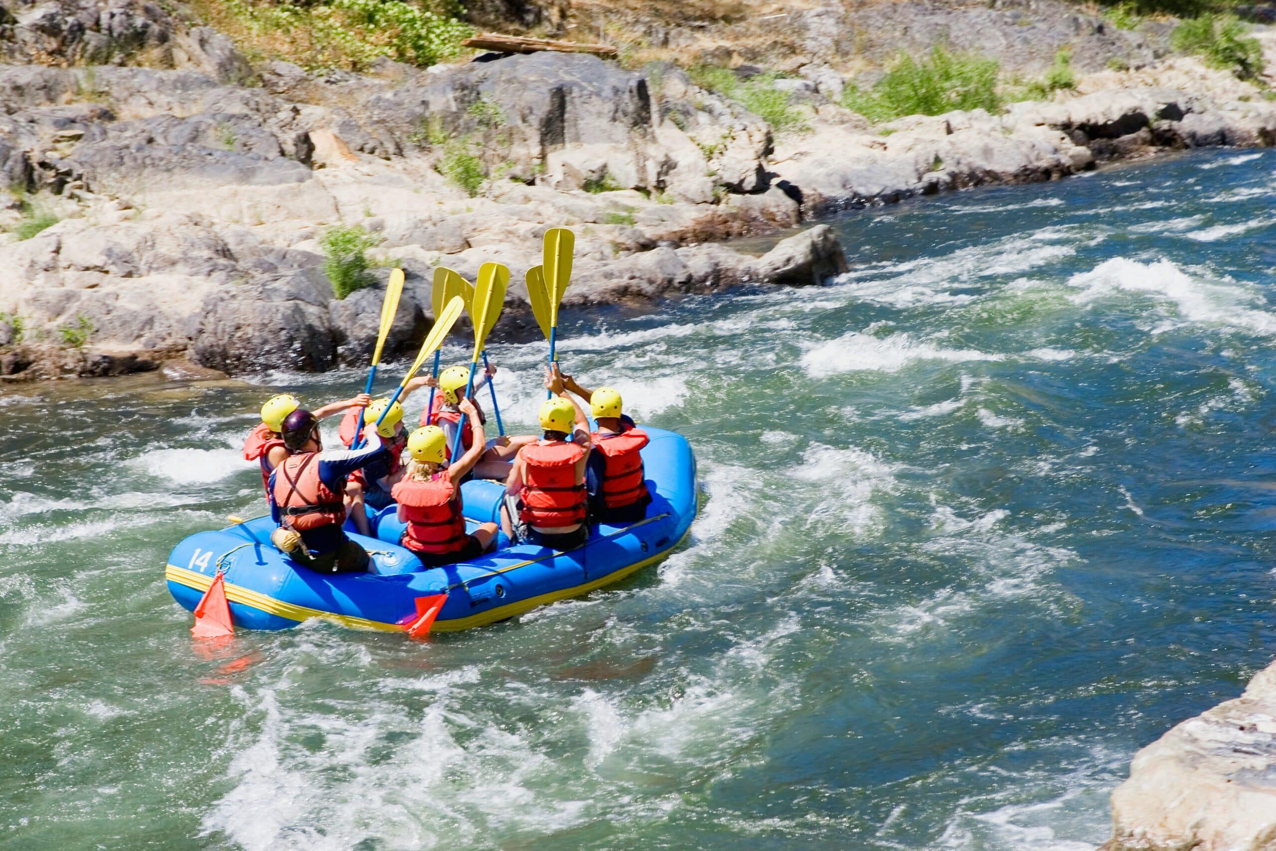 Eine Gruppe fährt auf einem Fluss mit einem Schlauchboot.