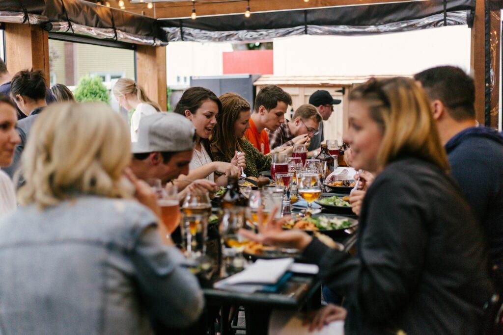 Teilnehmer sitzen an einem Tisch und feiern mit Essen